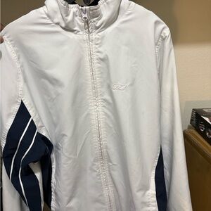 white and navy blue full-zip garment is a vintage Reebok track jacket